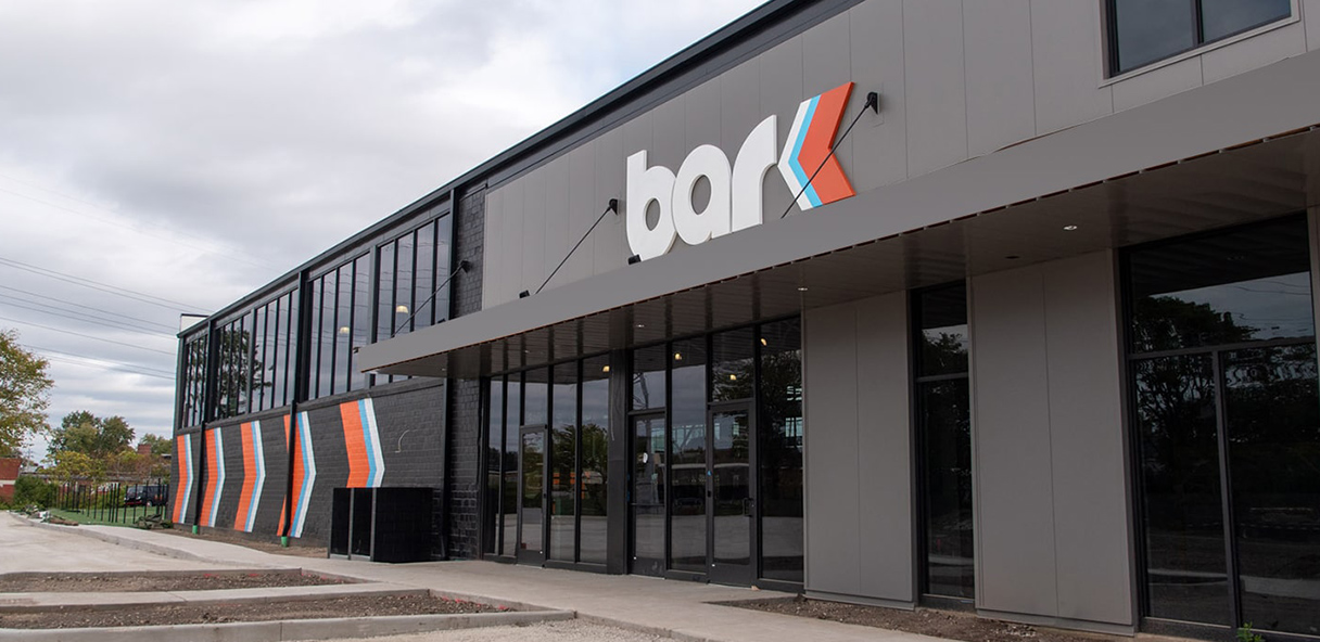 Photo of gray office building with glass doors.